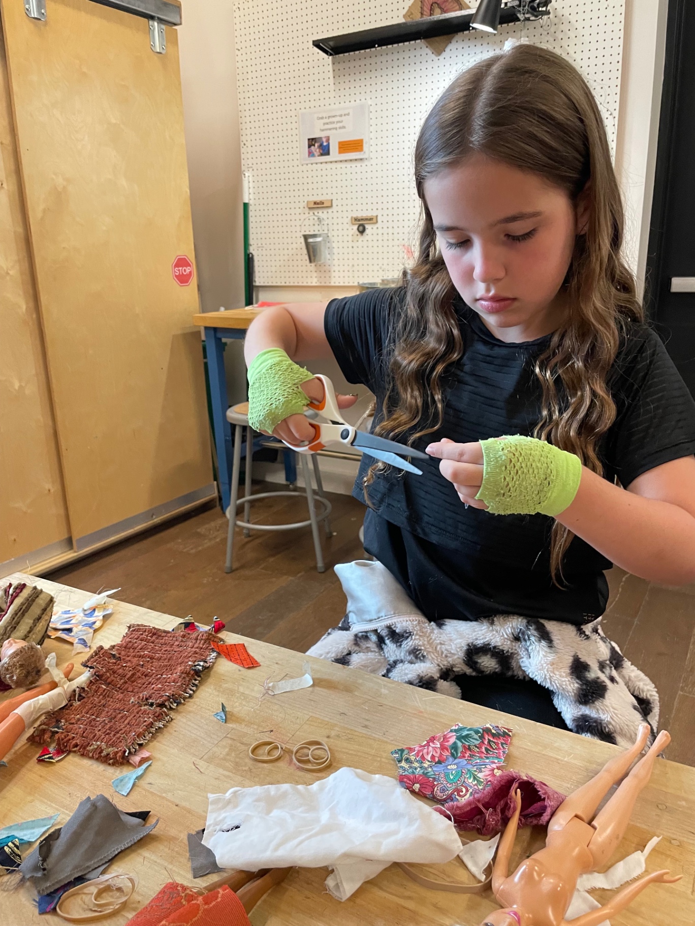 Cutting fabric carefully with scissors at the studio table
